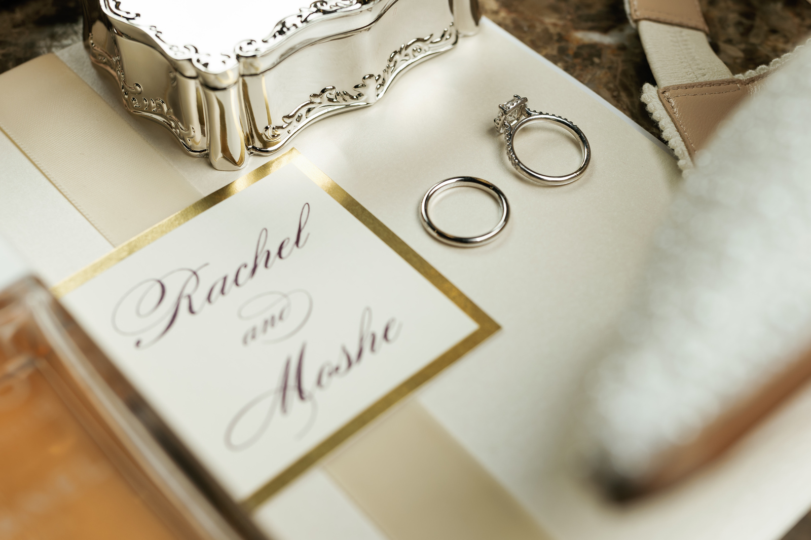 Close-up of two silver wedding rings and a ‘Rachel & Moshe’ engraved at The Mansion At Glen Cove, photographed by CJ Studios