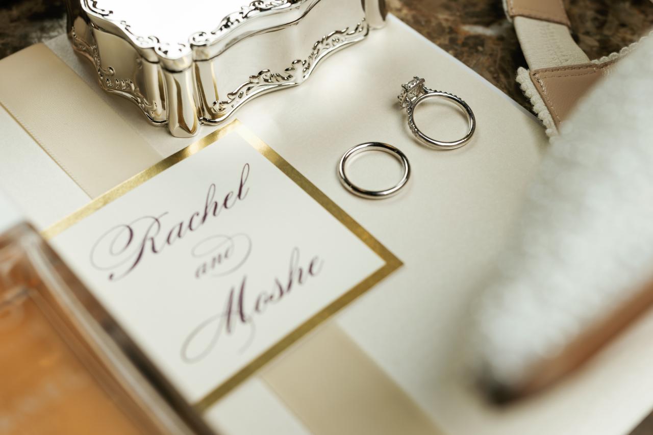 Close-up of two silver wedding rings and a ‘Rachel & Moshe’ engraved at The Mansion At Glen Cove, photographed by CJ Studios. Wedding photography.