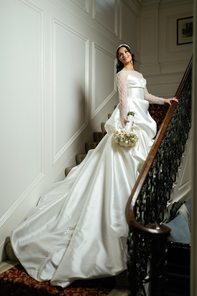 Bride in a white ballgown holding a bouquet while standing on a at The Mansion At Glen Cove, photographed by CJ Studios