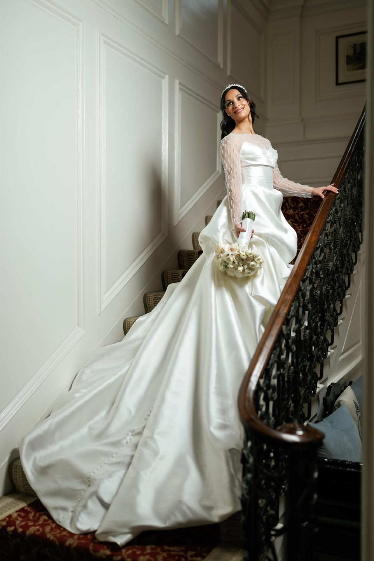 Bride in a white ballgown holding a bouquet while standing on a at The Mansion At Glen Cove, photographed by CJ Studios. Wedding photography.
