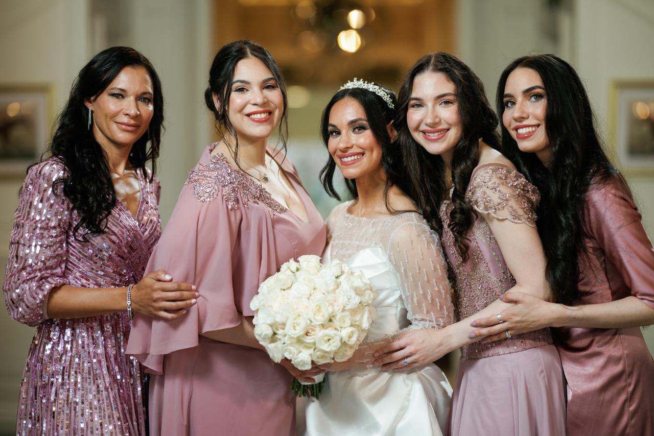 Bride holding a white bouquet while five friends in coordinated at The Mansion At Glen Cove, photographed by CJ Studios. Wedding photography.