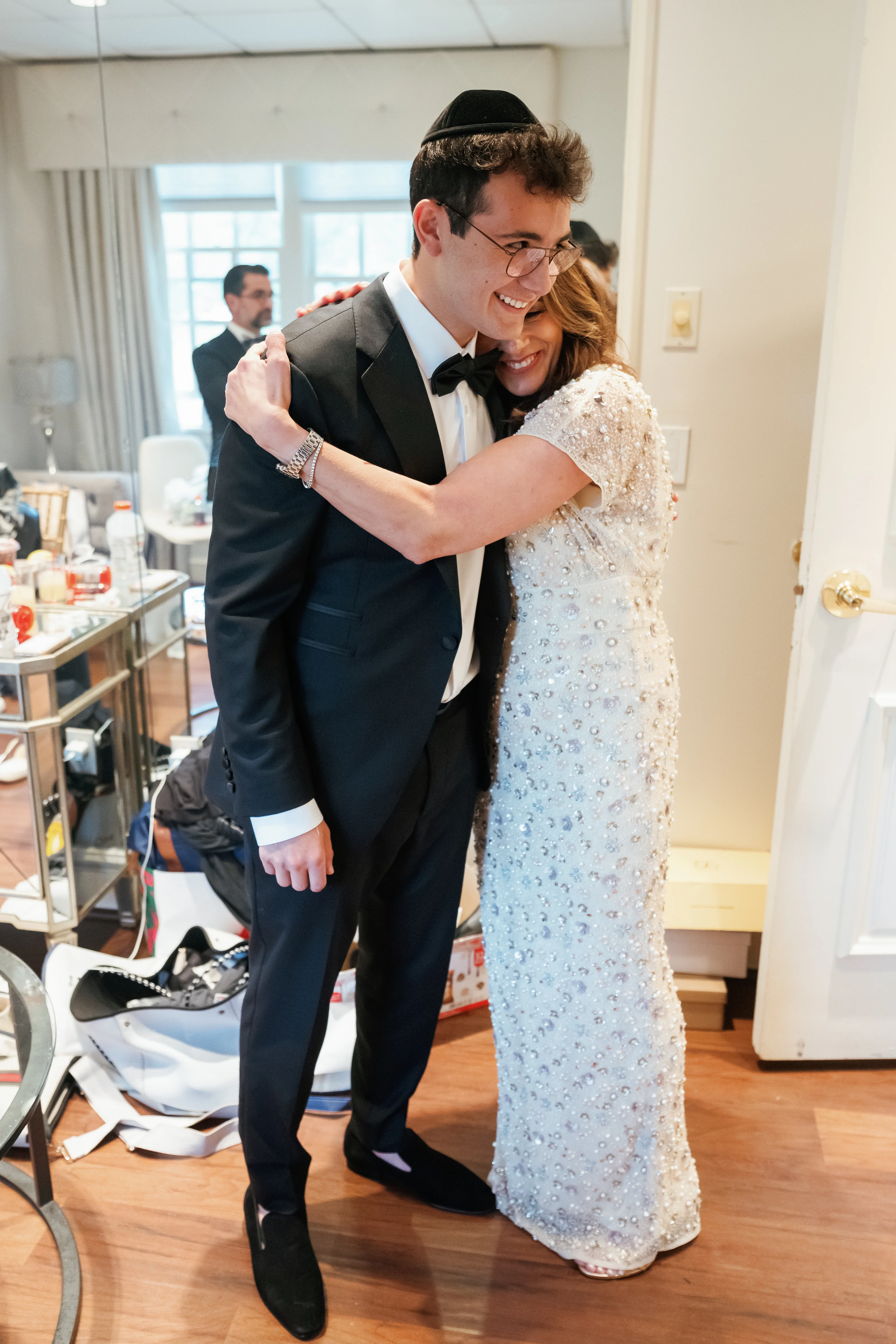 Bride and groom embracing and smiling during the celebration, captured mid-moment indoors.