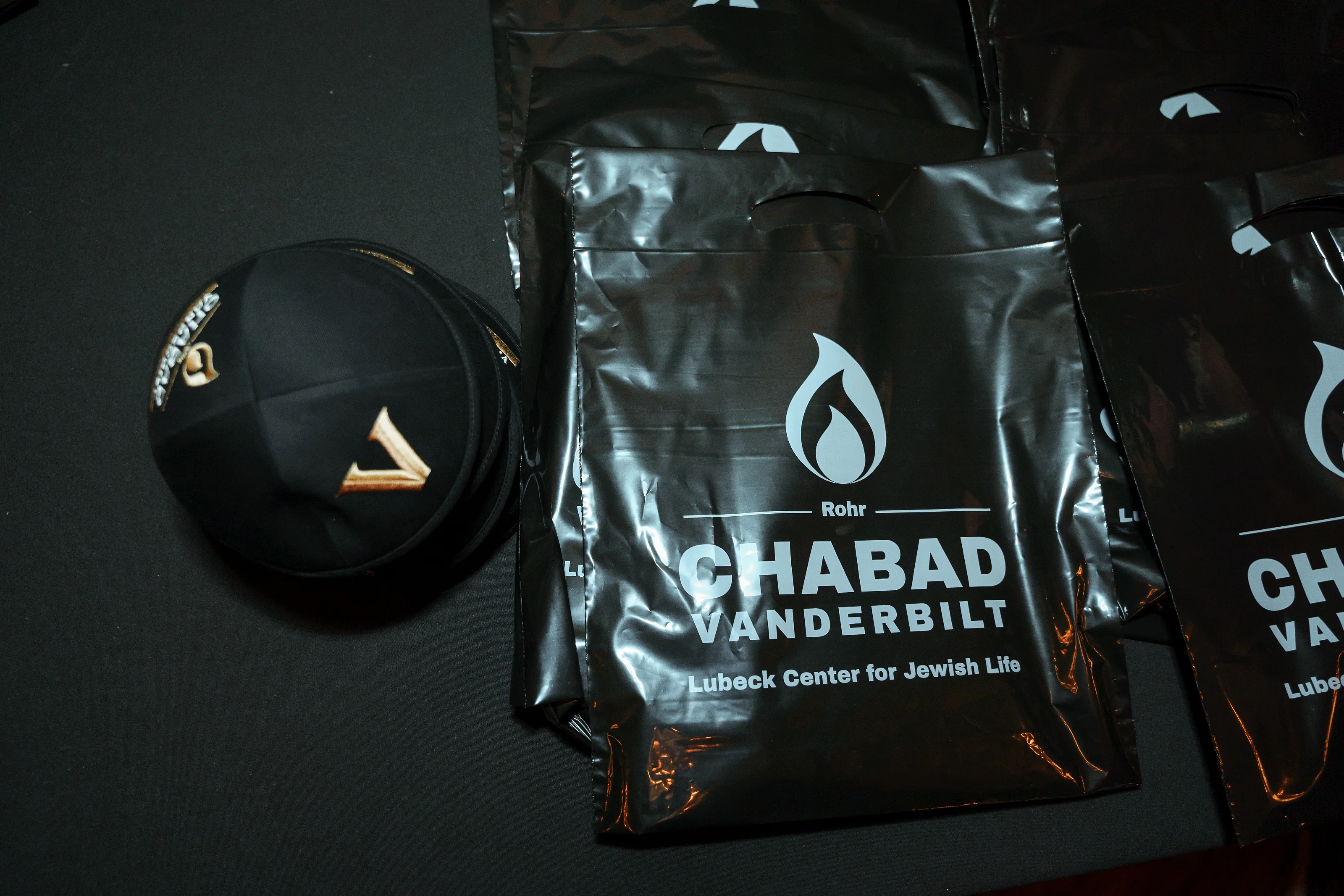 Close-up of black event items and branded packaging on a dark table.