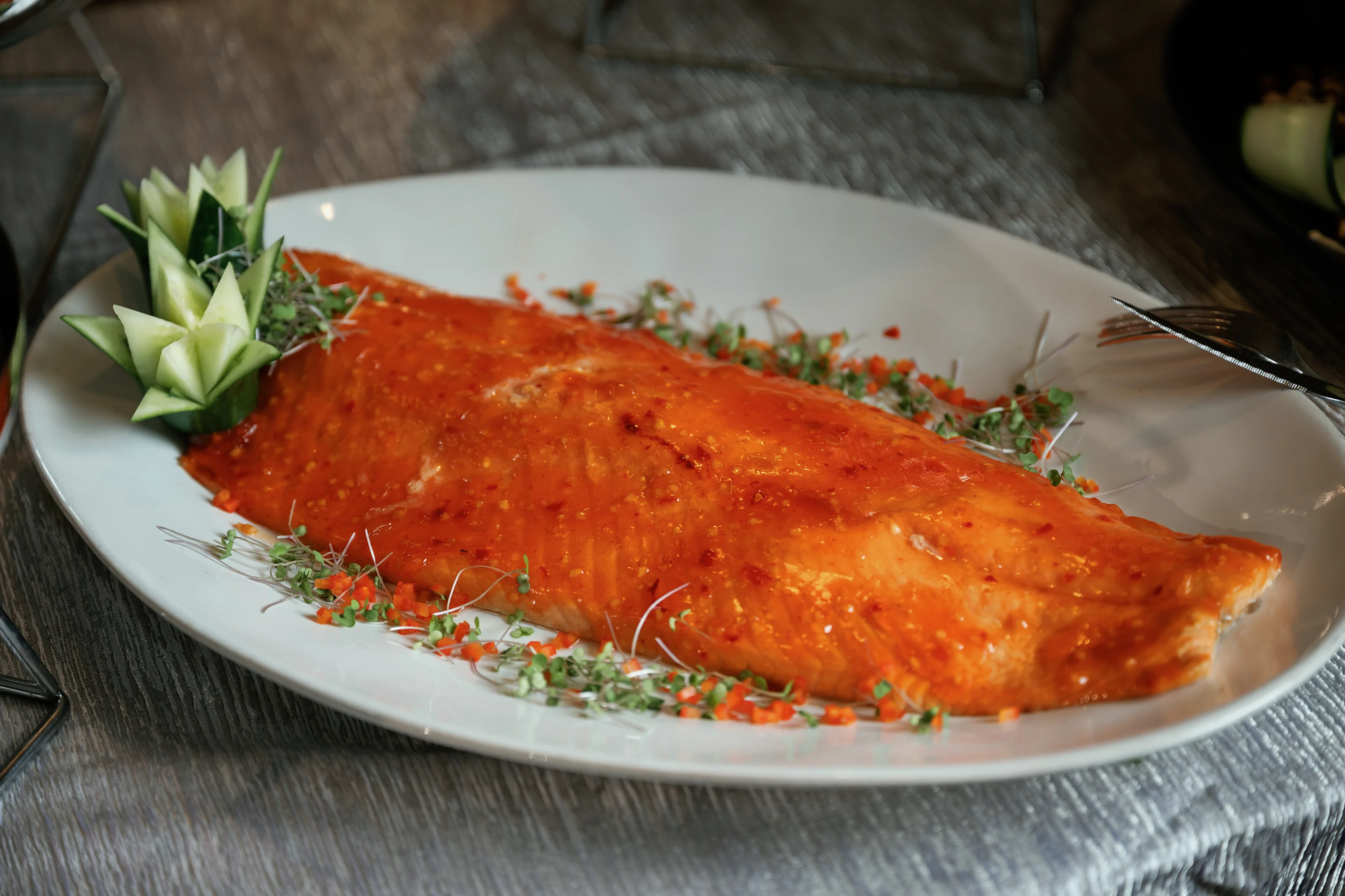 Whole salmon fillet on a decorated serving platter