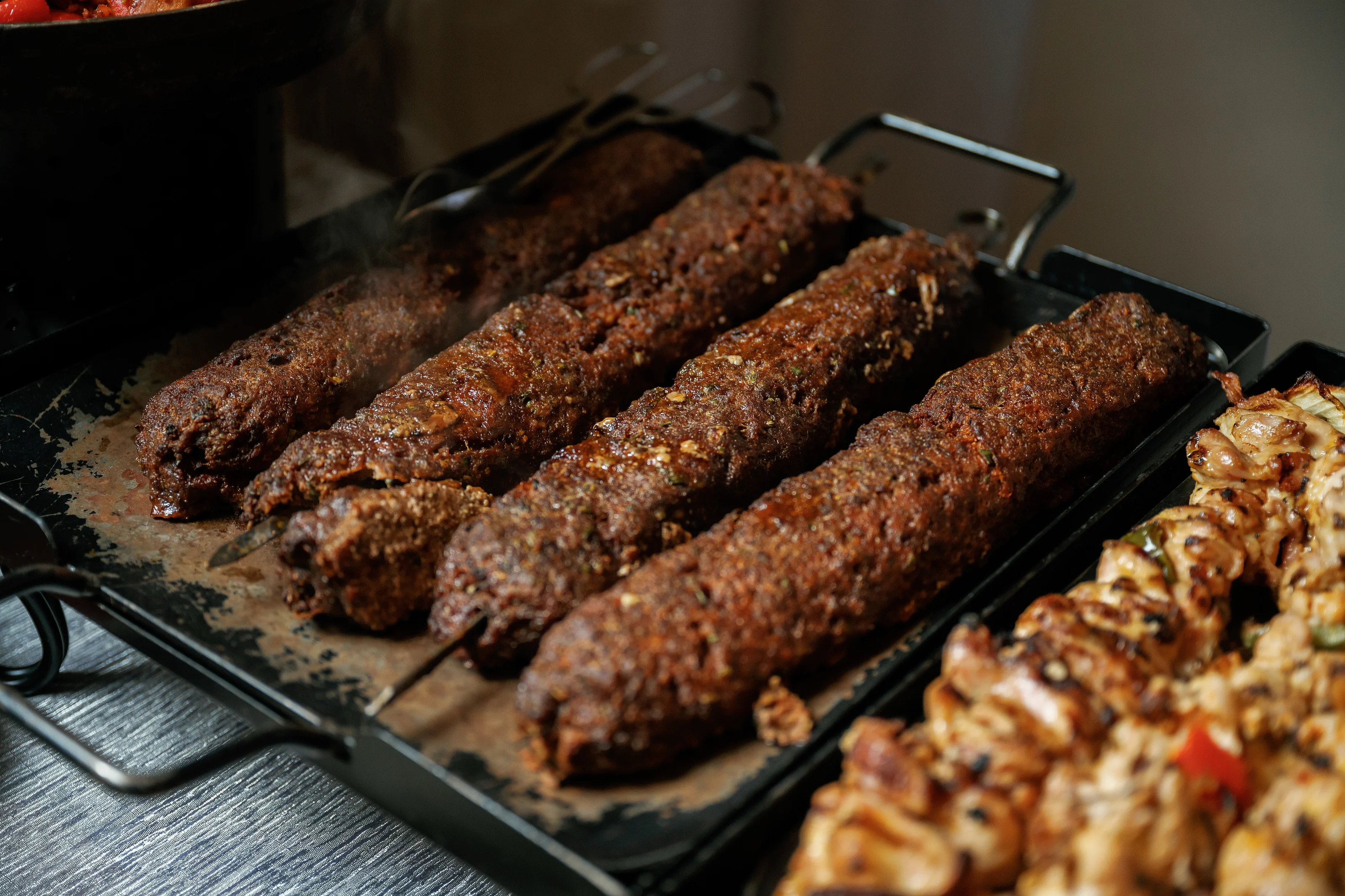 Long grilled kebabs on a catering platter