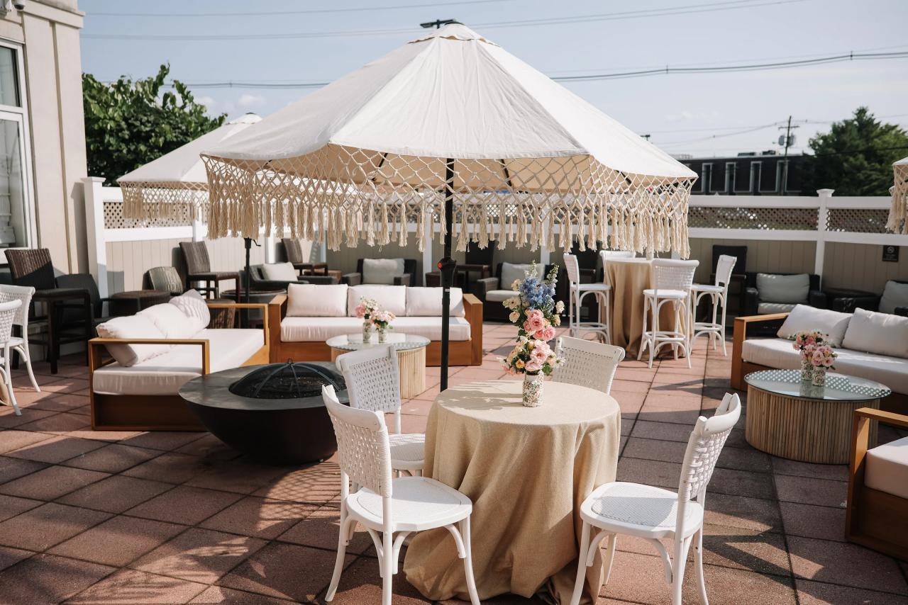 White outdoor canopy with lounge seating and floral centerpieces at the celebration