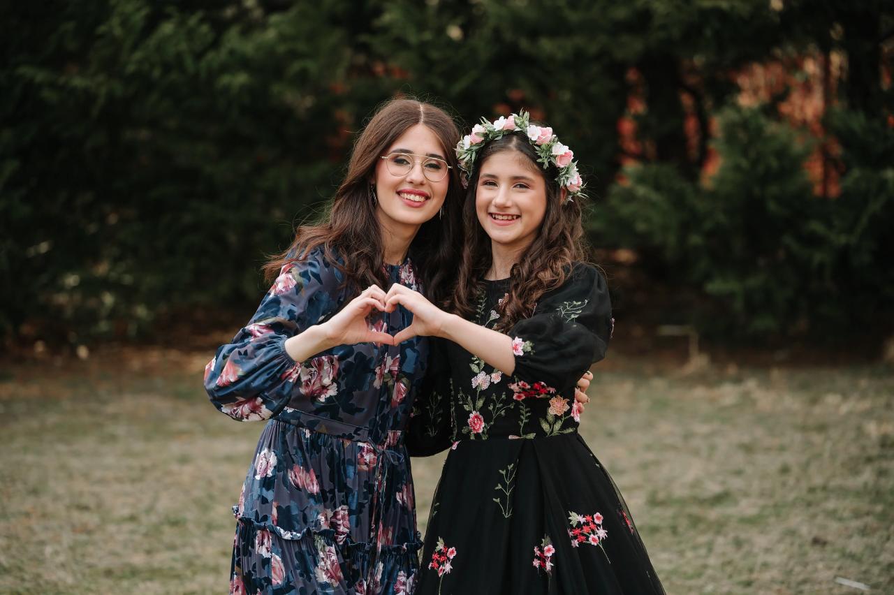 Mother and daughter making a heart with their hands