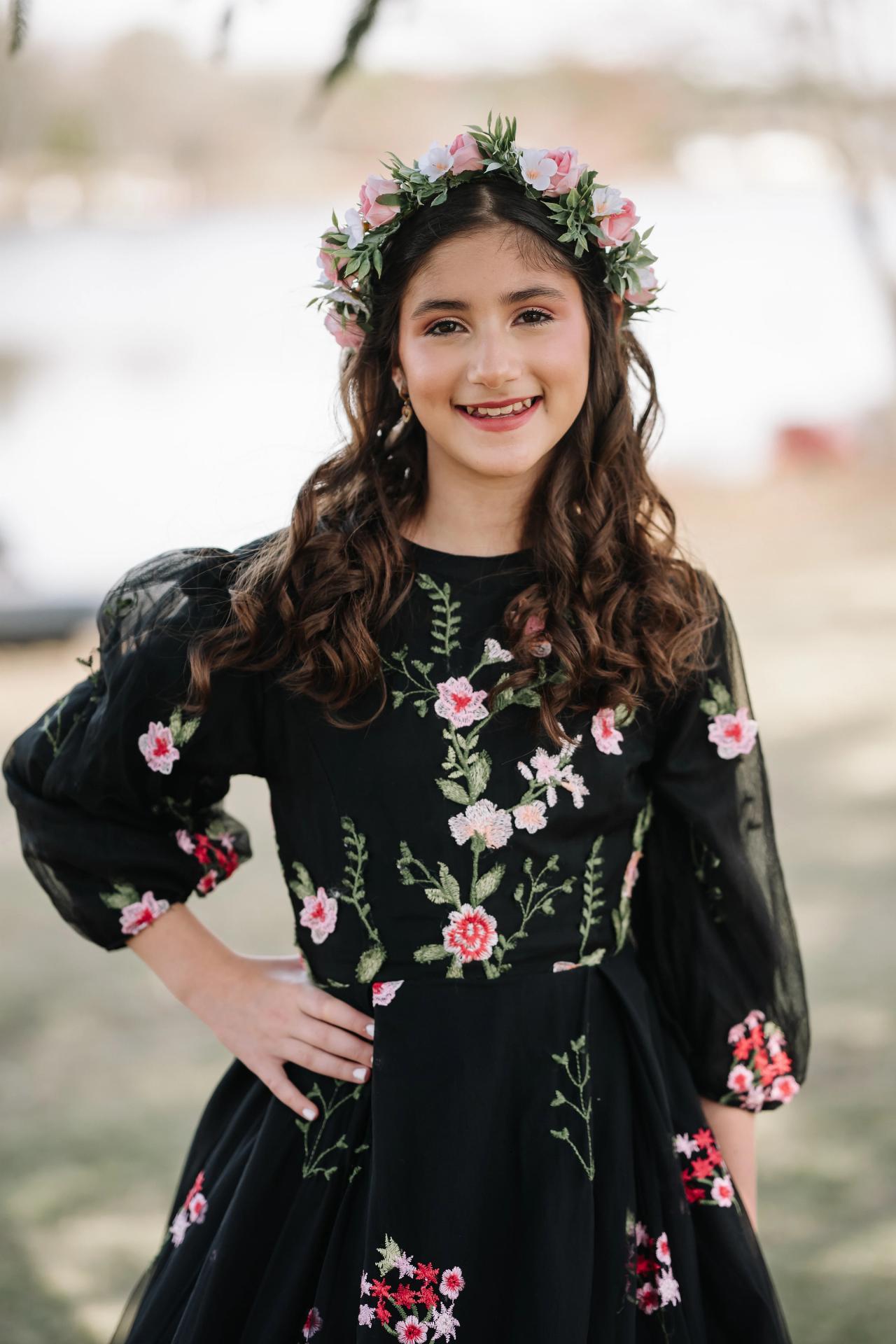 Bat Mitzvah girl smiling in a floral dress and flower crown