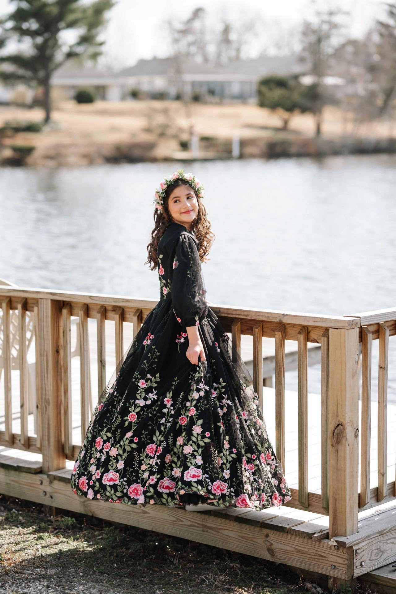 Girl turning in a floral dress beside the water