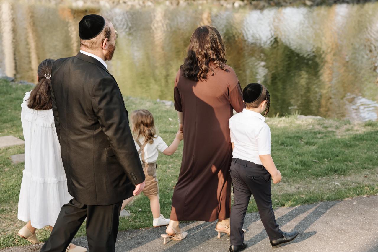 Family walking beside a pond during an outdoor Upsherin session