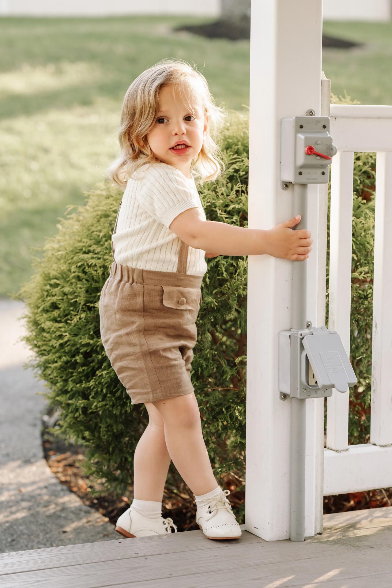 Child looking toward the camera from a white gazebo doorway