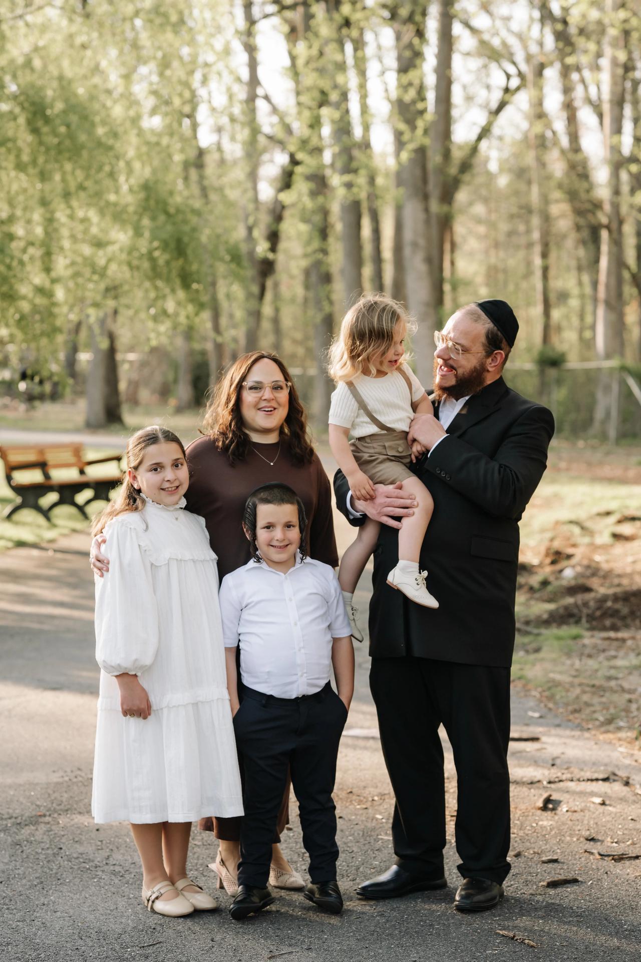 Father kissing his young child during a family portrait