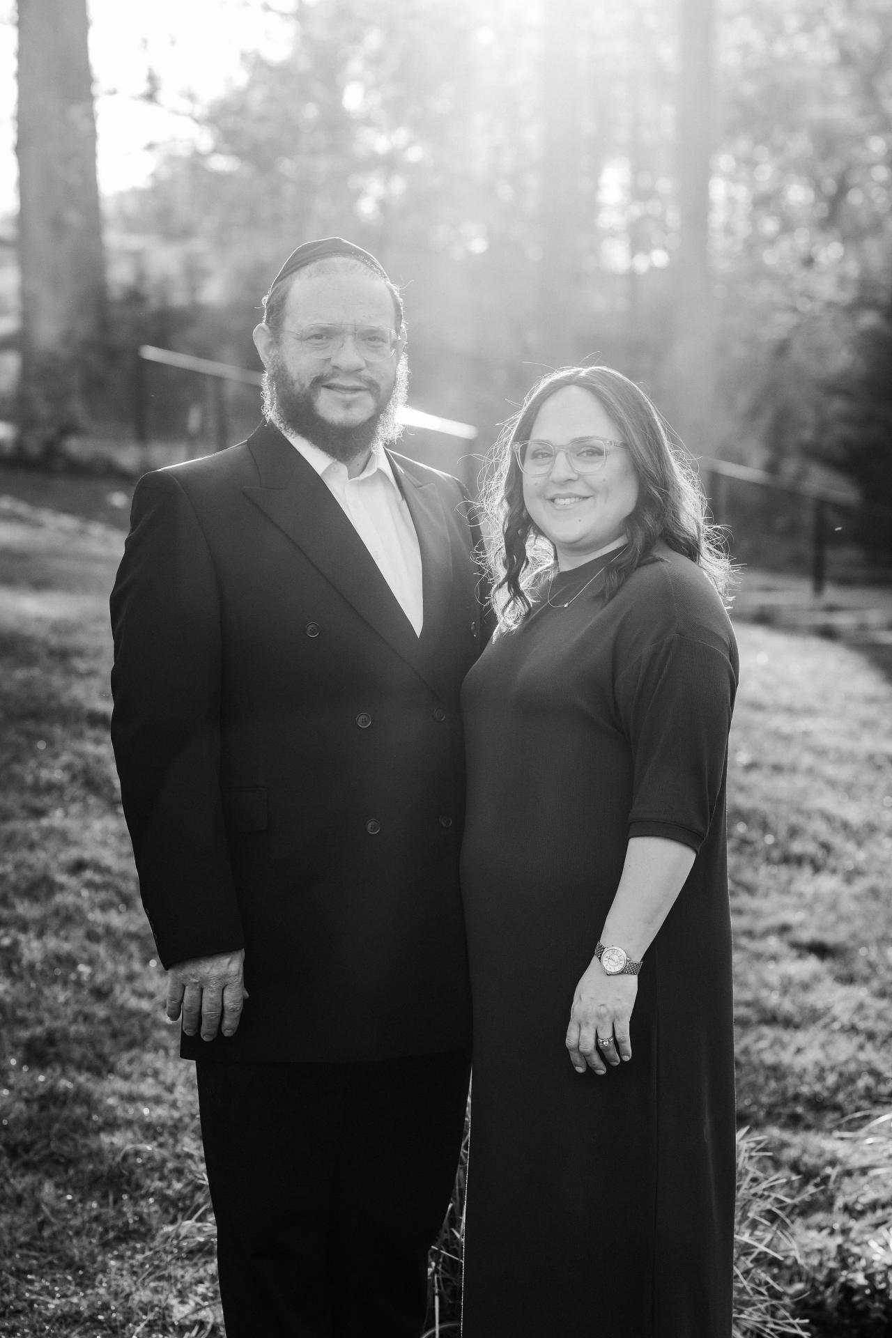 Black-and-white portrait of a couple beneath spring trees