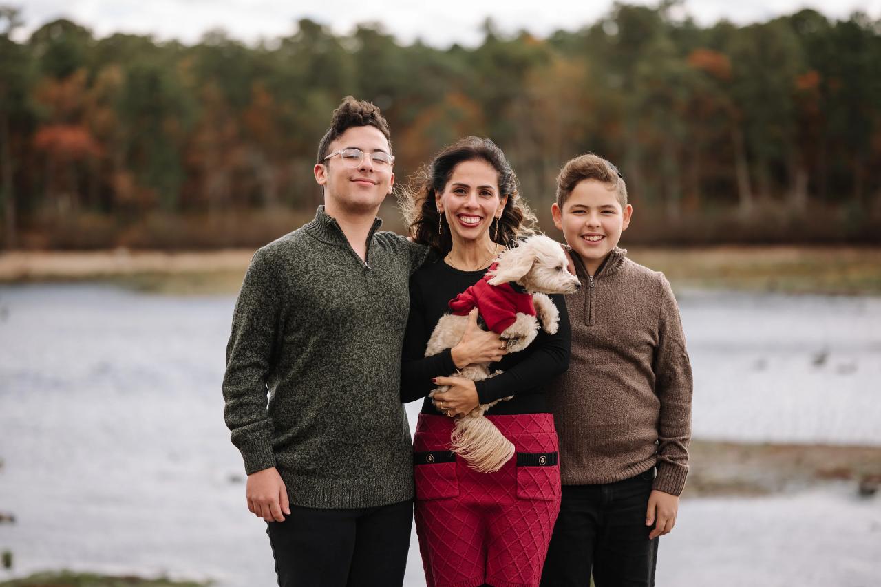 Family of three with a small dog beside a lake during an outdoor portrait session