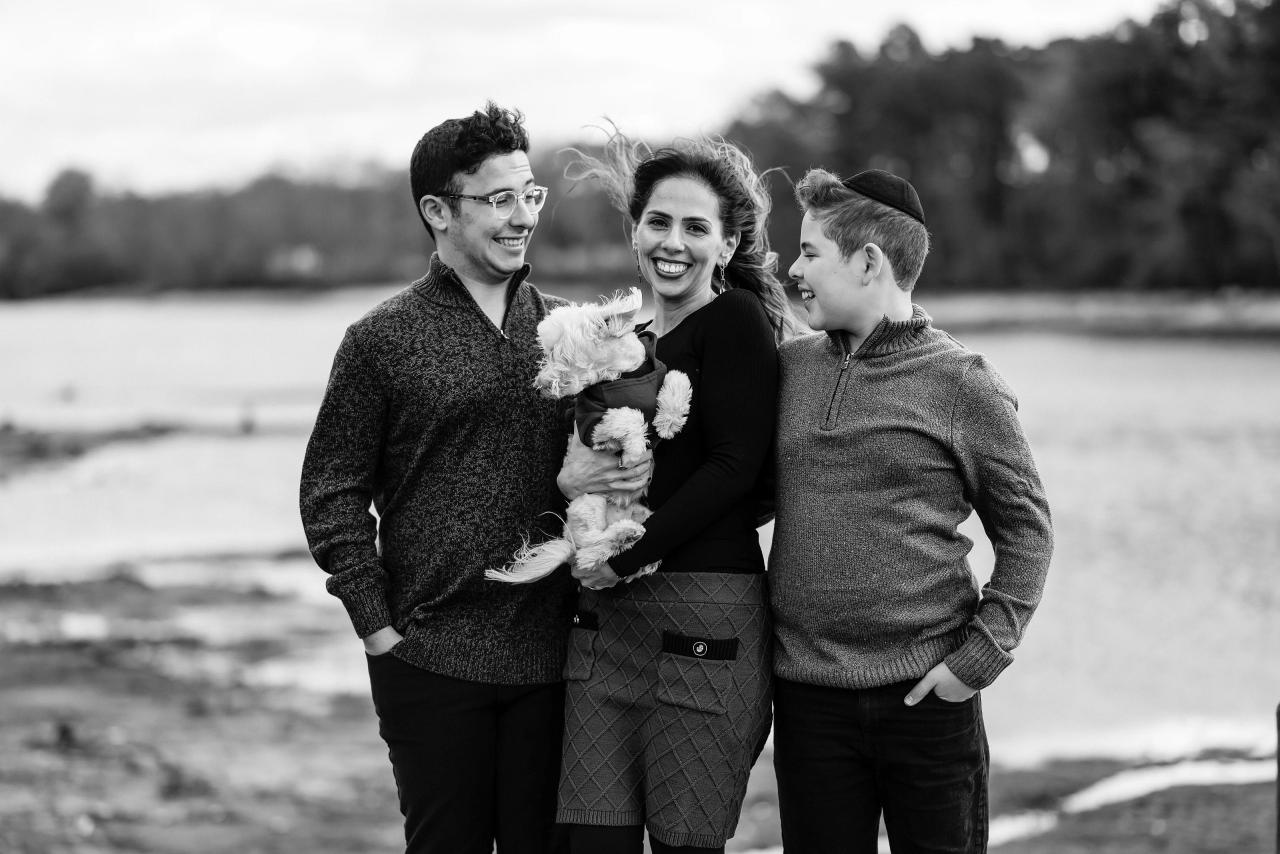 Black-and-white family portrait sharing a smile beside the lake