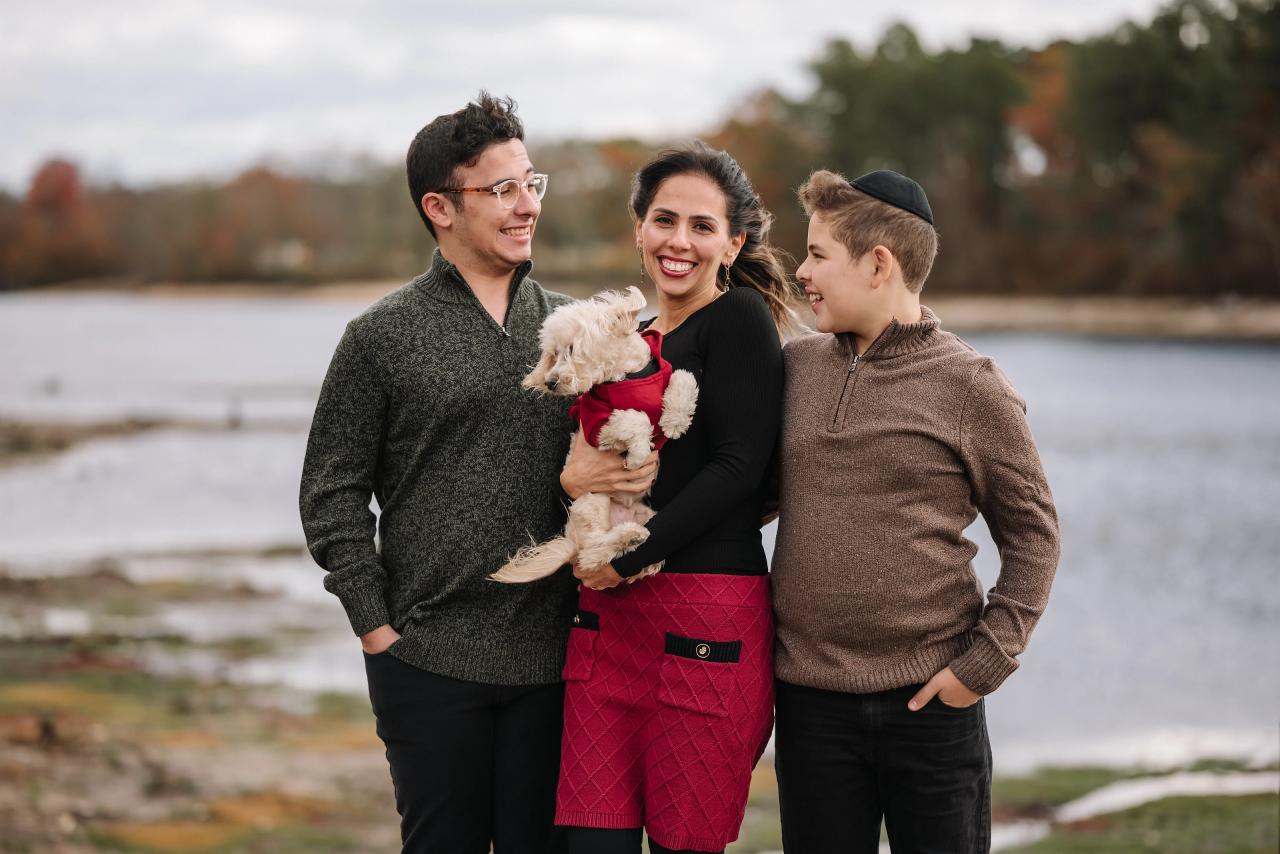Candid family portrait with a small dog by the water