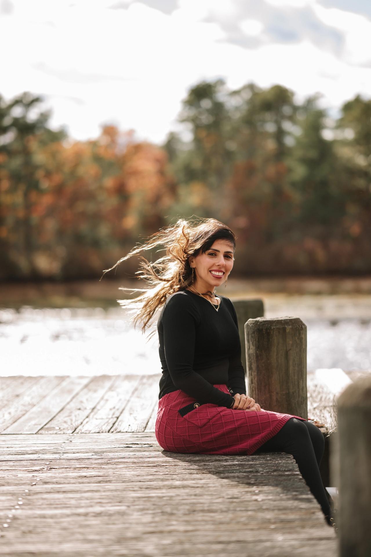 Woman seated on a wooden dock during a lakeside portrait session