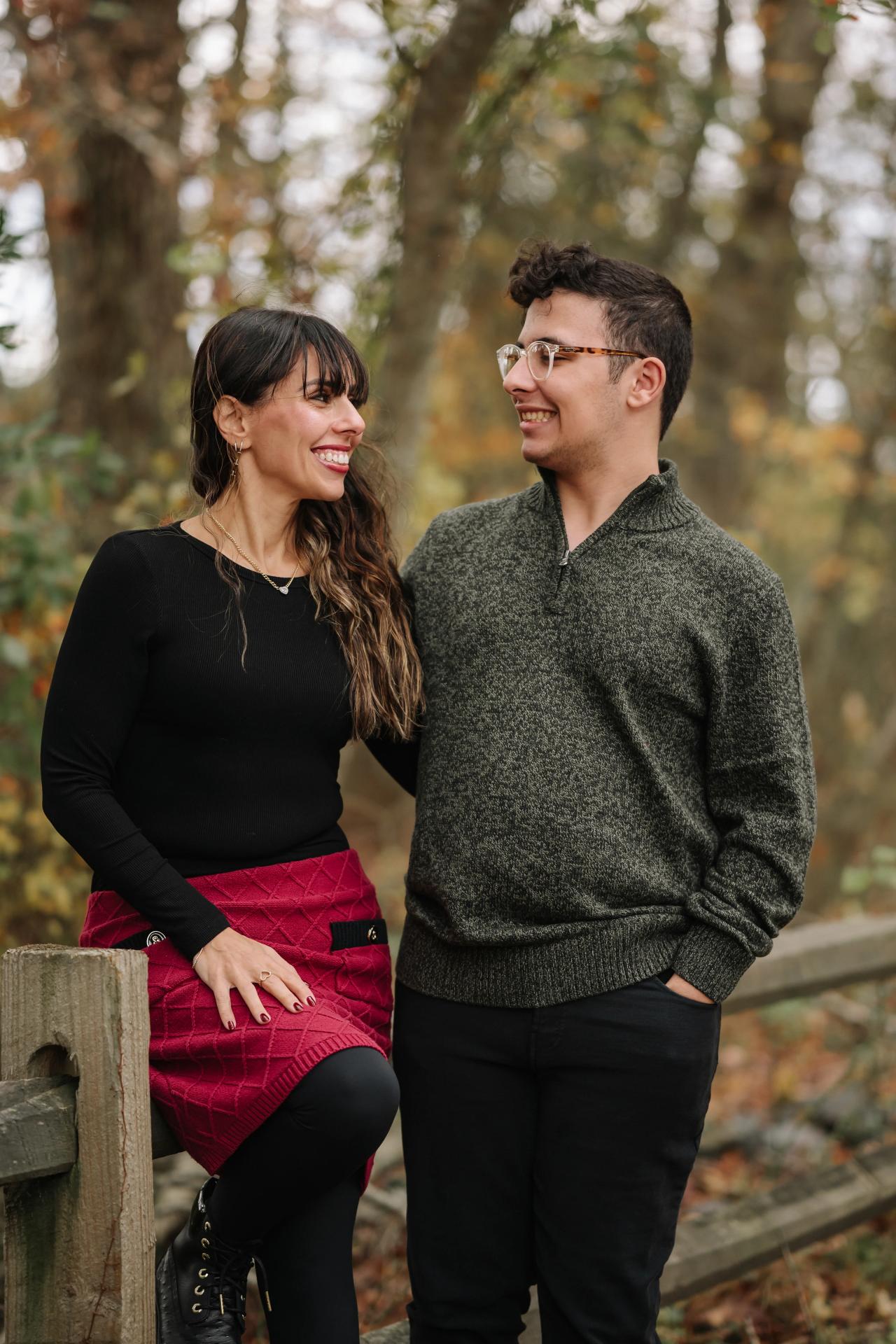Two family members smiling at each other during an autumn portrait session
