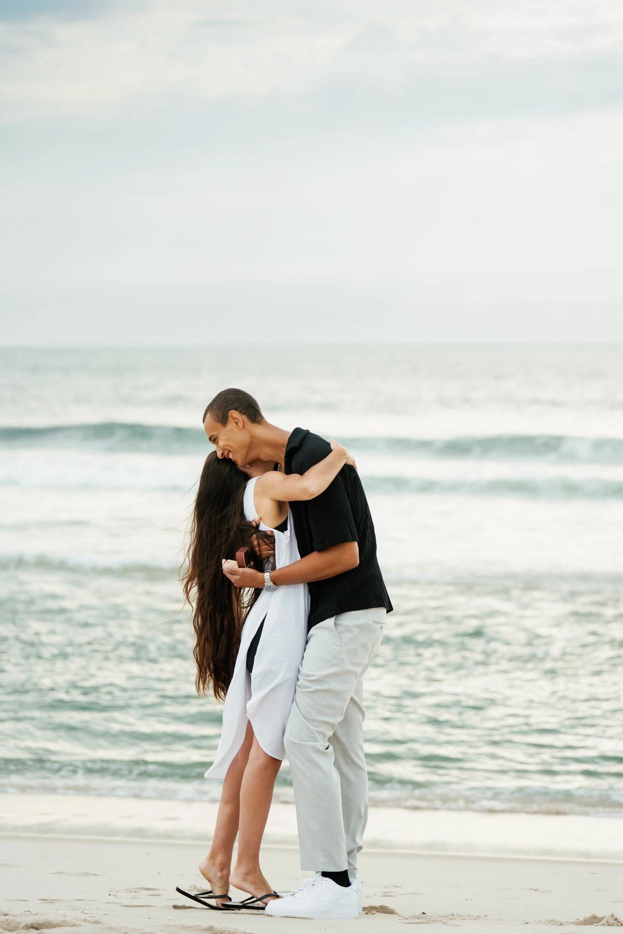 Couple embracing immediately after the beach proposal