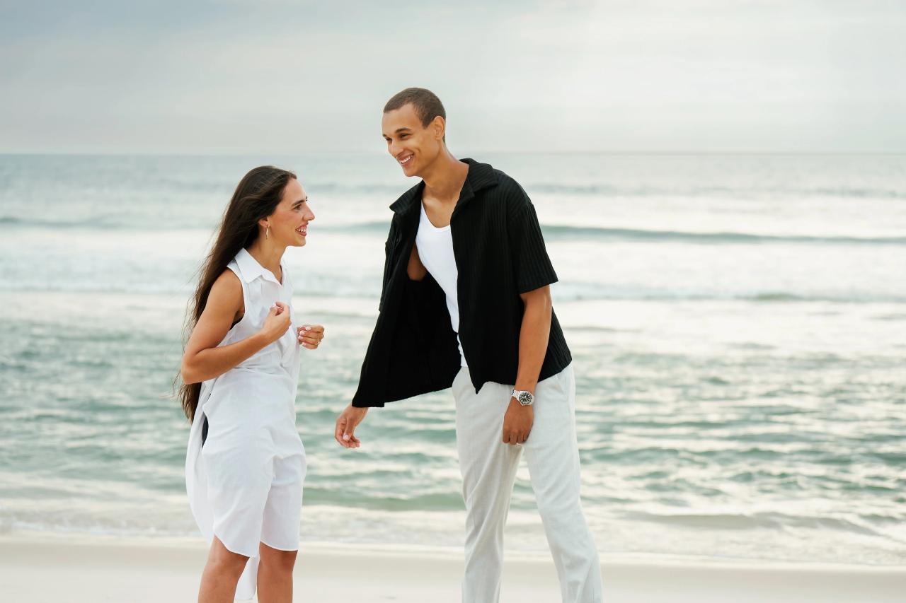 Couple laughing together on the beach after the proposal
