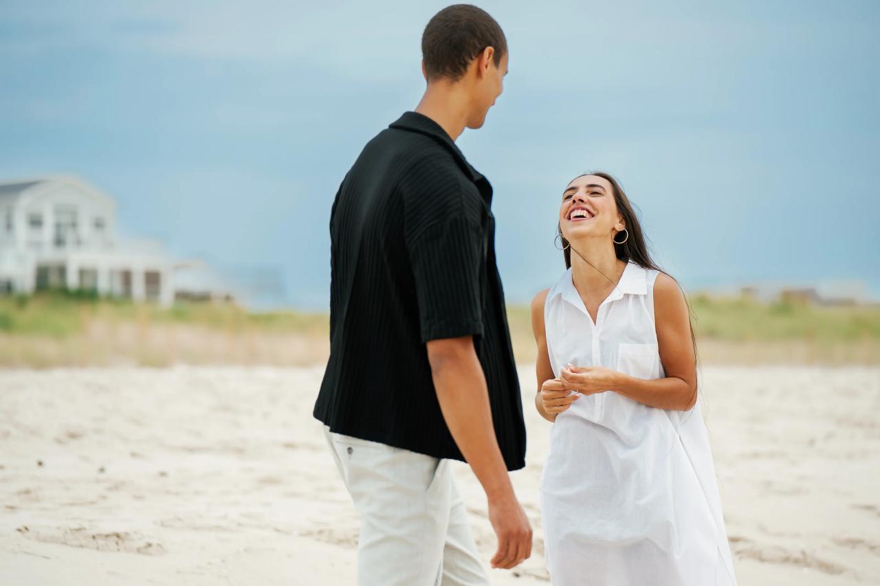 Woman laughing with her partner during their beach portrait session