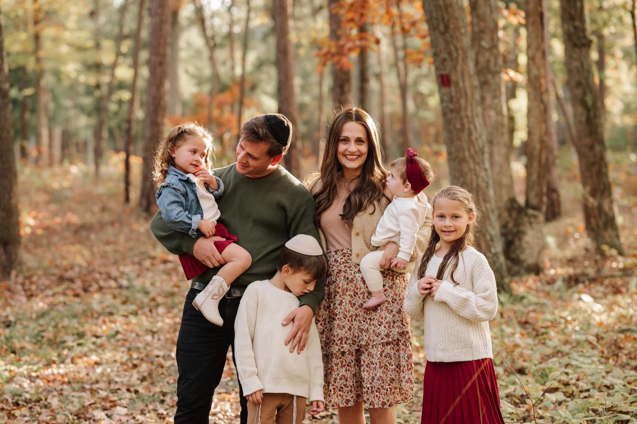 Parents and four children gathered along a woodland path