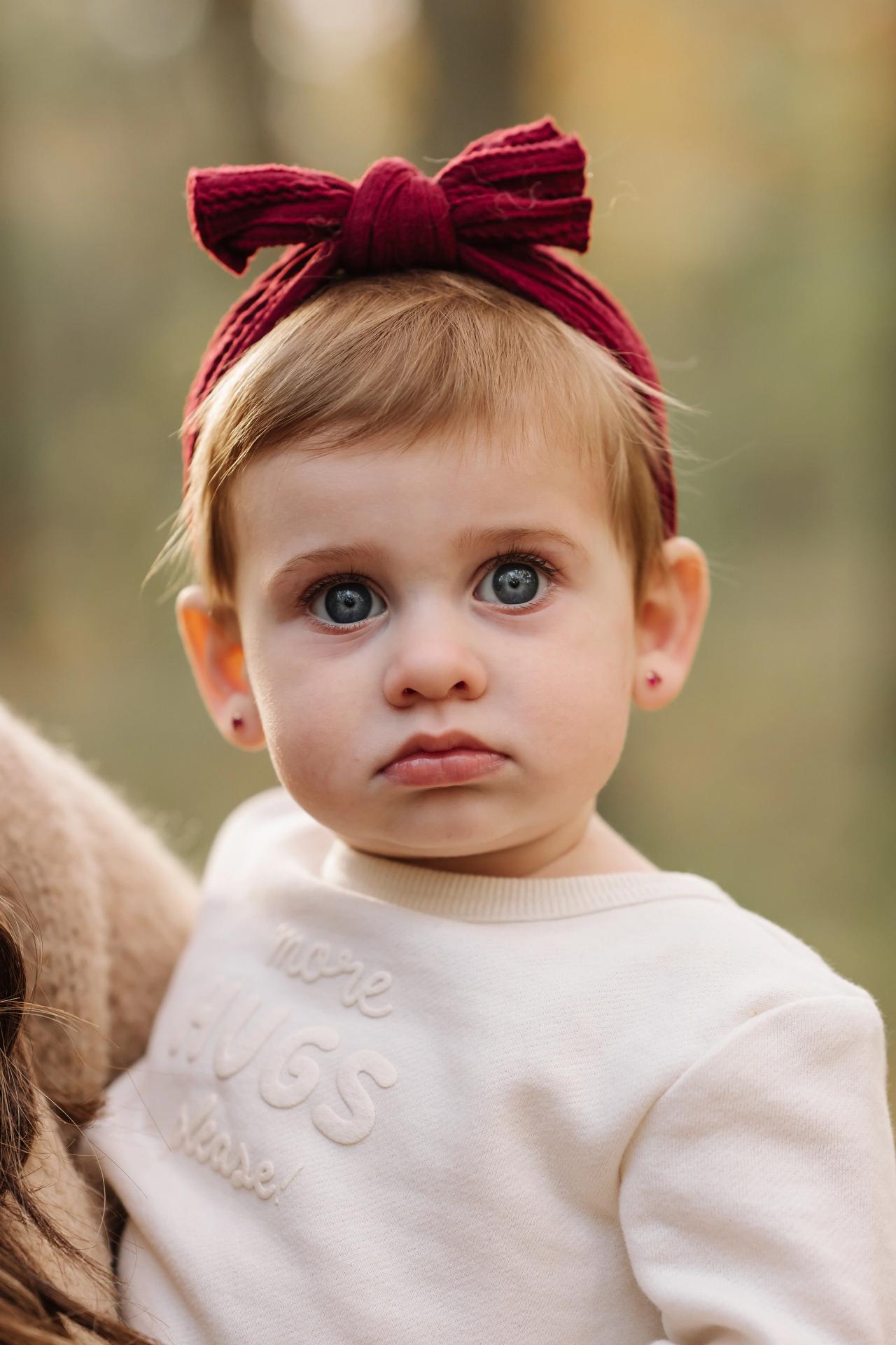 Baby wearing a bow during an autumn family session