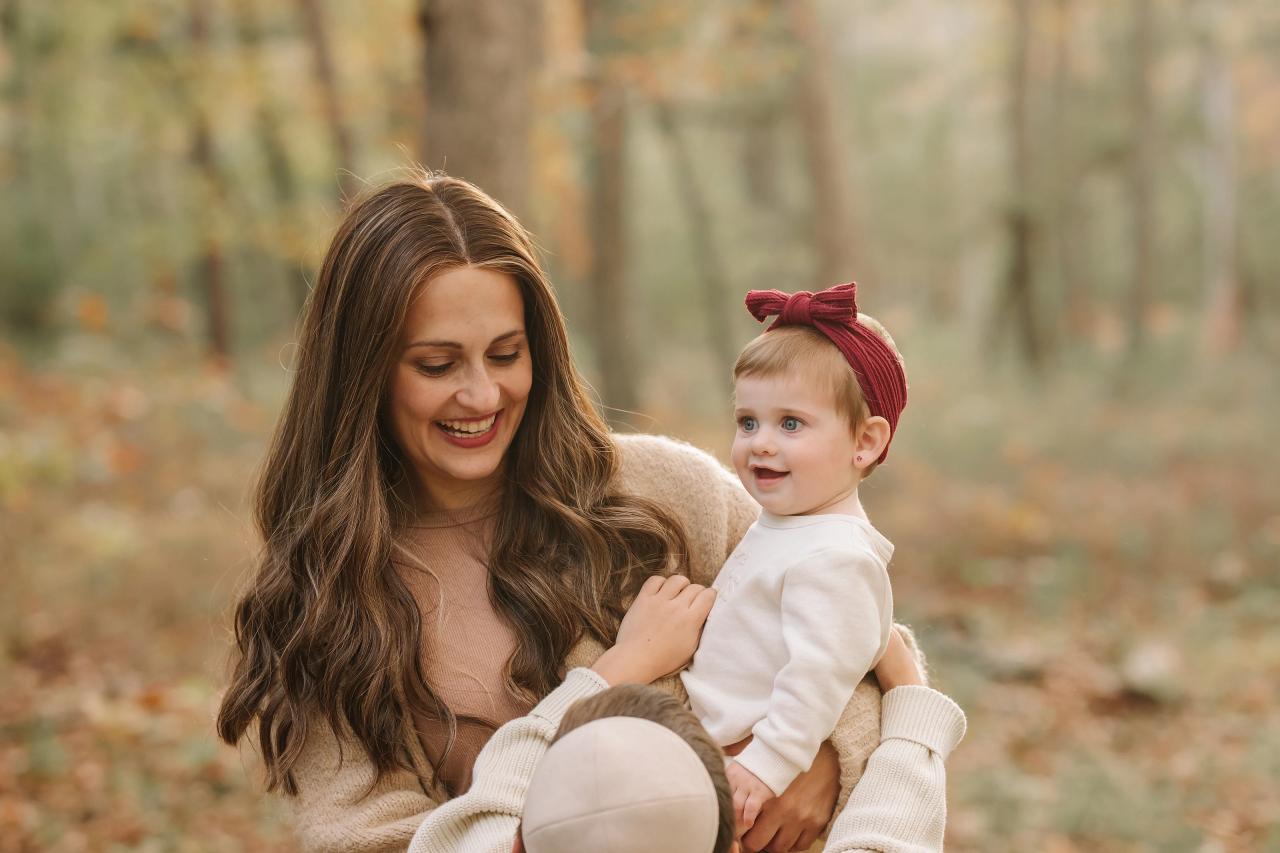 Mother holding her baby beside an autumn woodland path