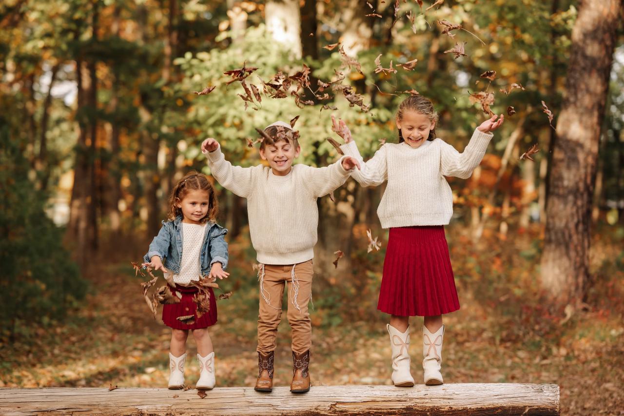 Children tossing autumn leaves into the air