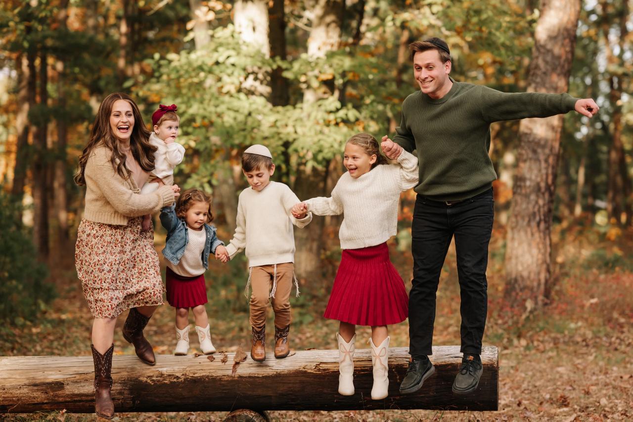 Family laughing together beside a fallen log