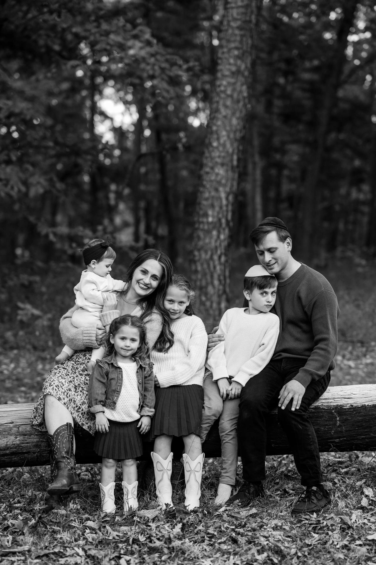 Black-and-white family portrait on a fallen log