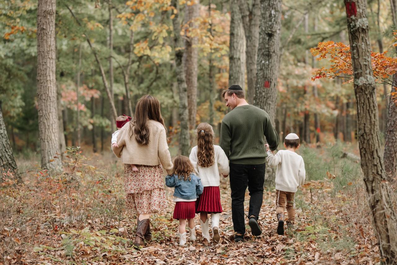 Family walking away together through the autumn woods