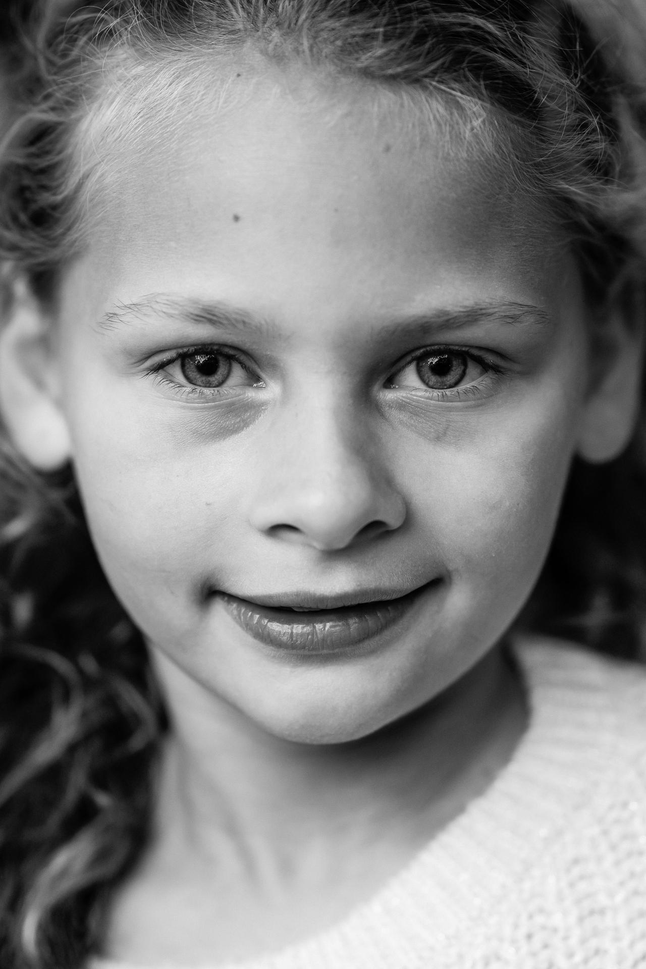 Black-and-white close-up portrait of a girl outdoors