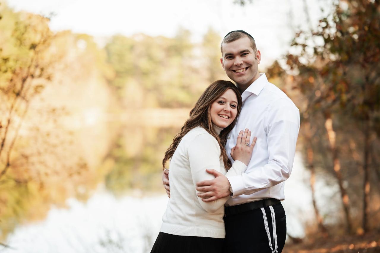 Parents embracing beside the lake during a fall portrait session