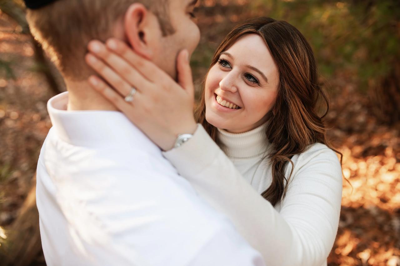 Mother smiling as she gently holds her partner’s face