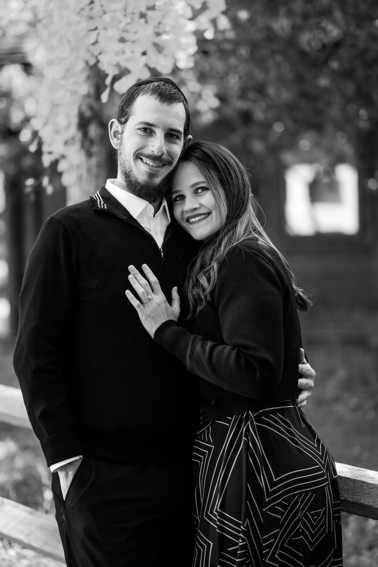 Black-and-white portrait of parents embracing outdoors