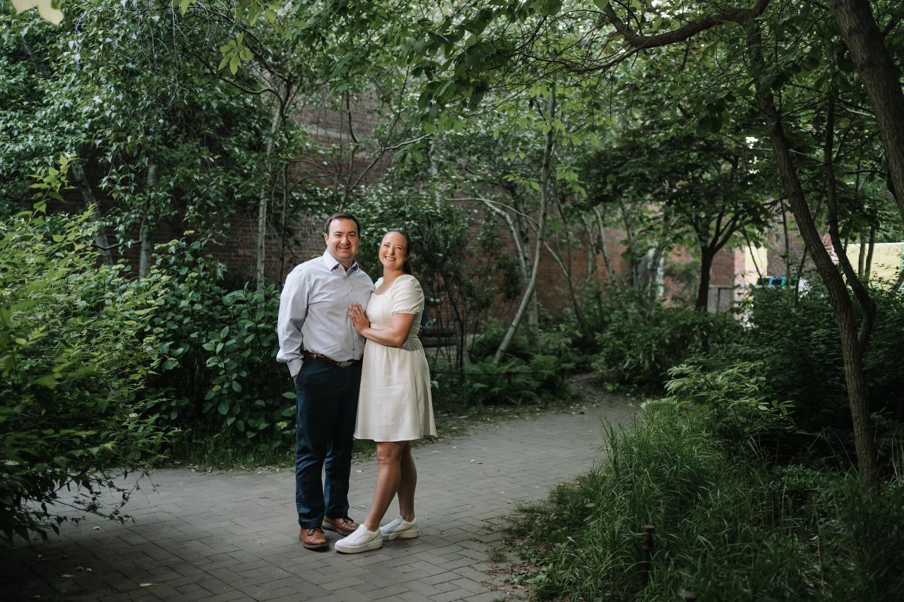 Engaged couple standing together on a leafy garden path