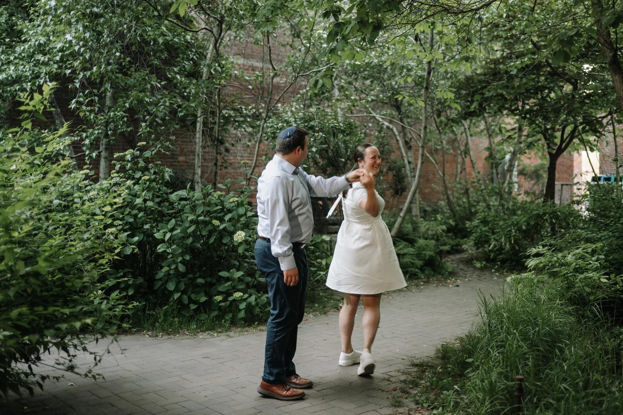 Couple twirling together during a relaxed garden engagement session