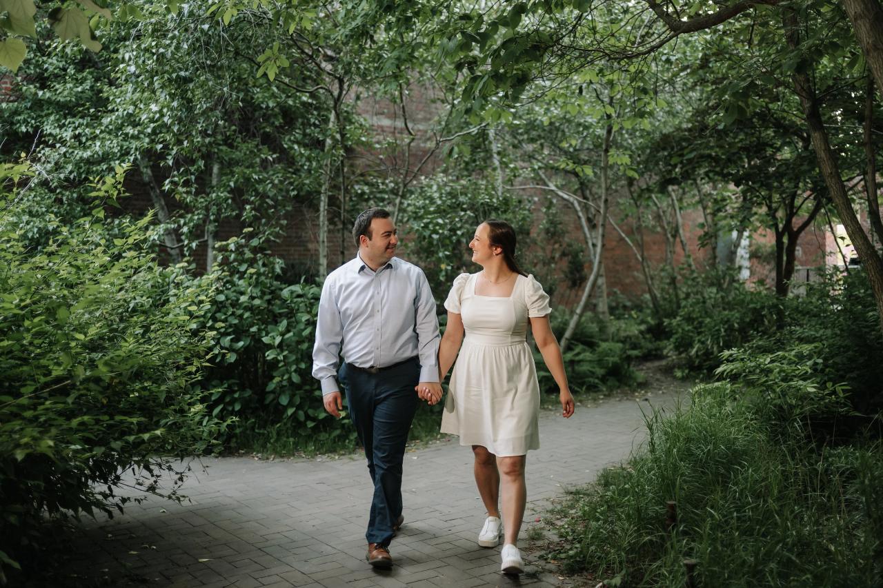 Couple walking hand in hand along a shaded garden path