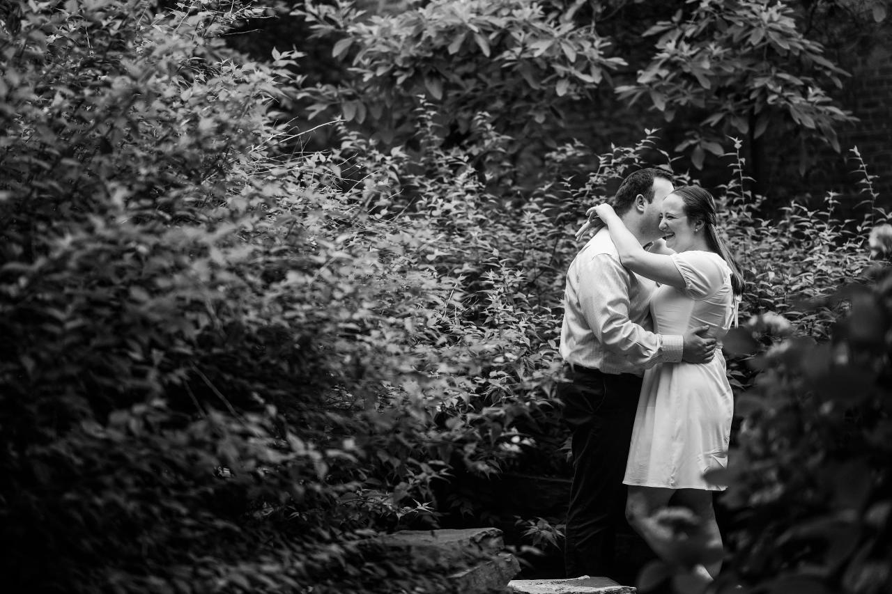 Black-and-white portrait of a couple embracing in the garden