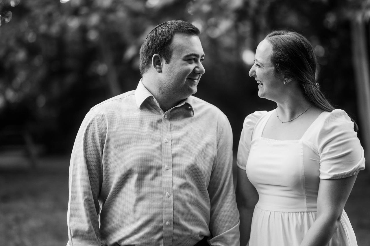 Black-and-white candid portrait of a couple smiling together