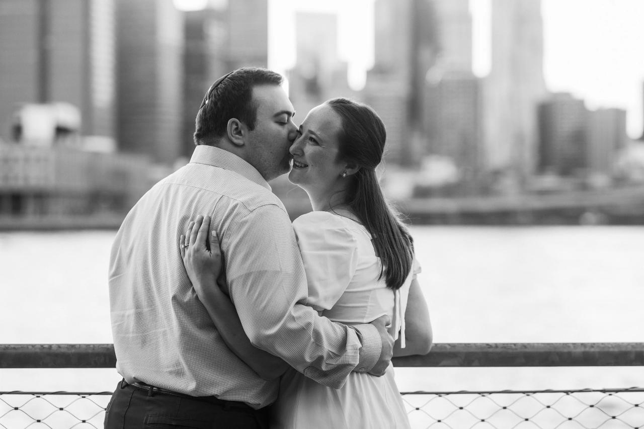 Black-and-white close portrait of a couple beside the waterfront