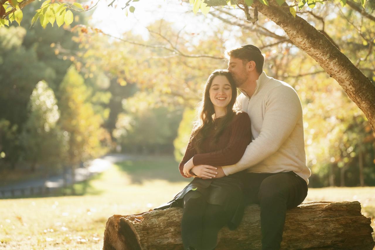 Man kissing his smiling partner on the forehead during outdoor portraits