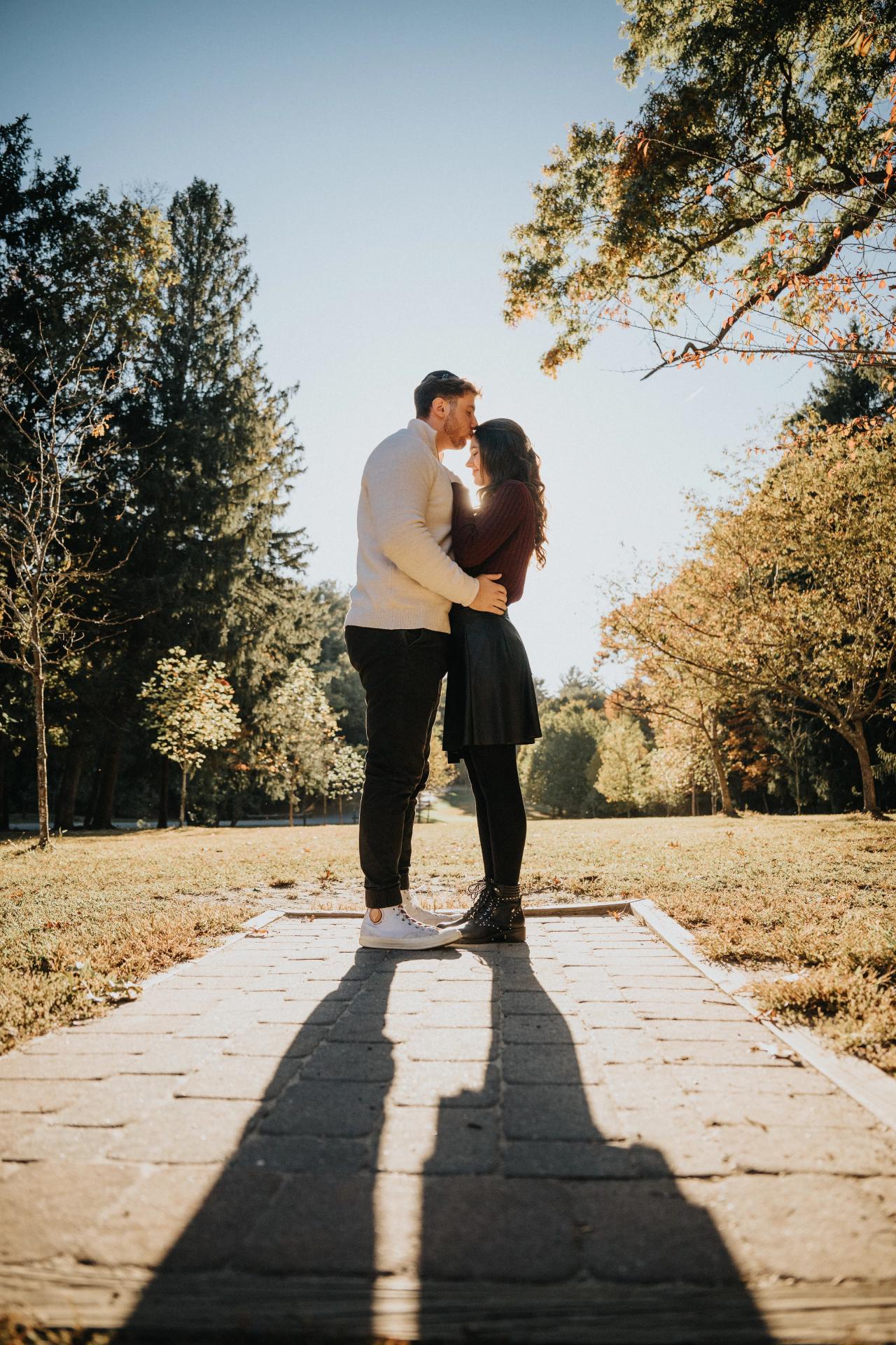 Couple embracing on a stone path with long afternoon shadows