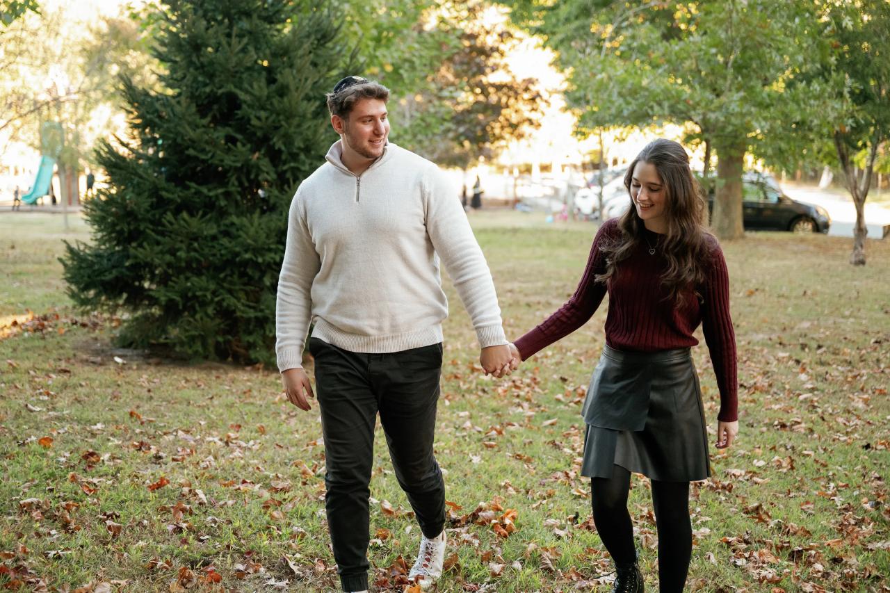 Couple walking together through a leaf-covered park