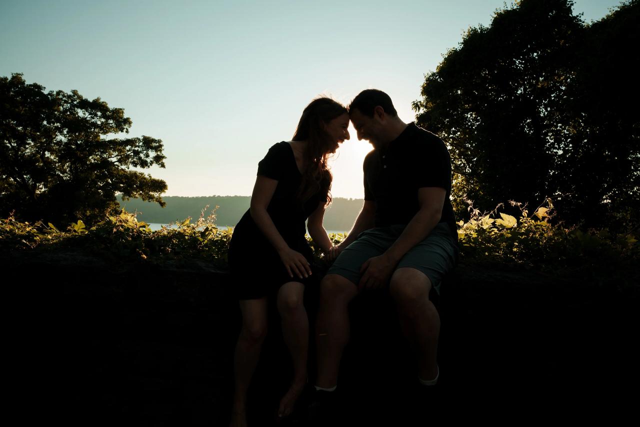 Silhouette of an engaged couple touching foreheads at sunset
