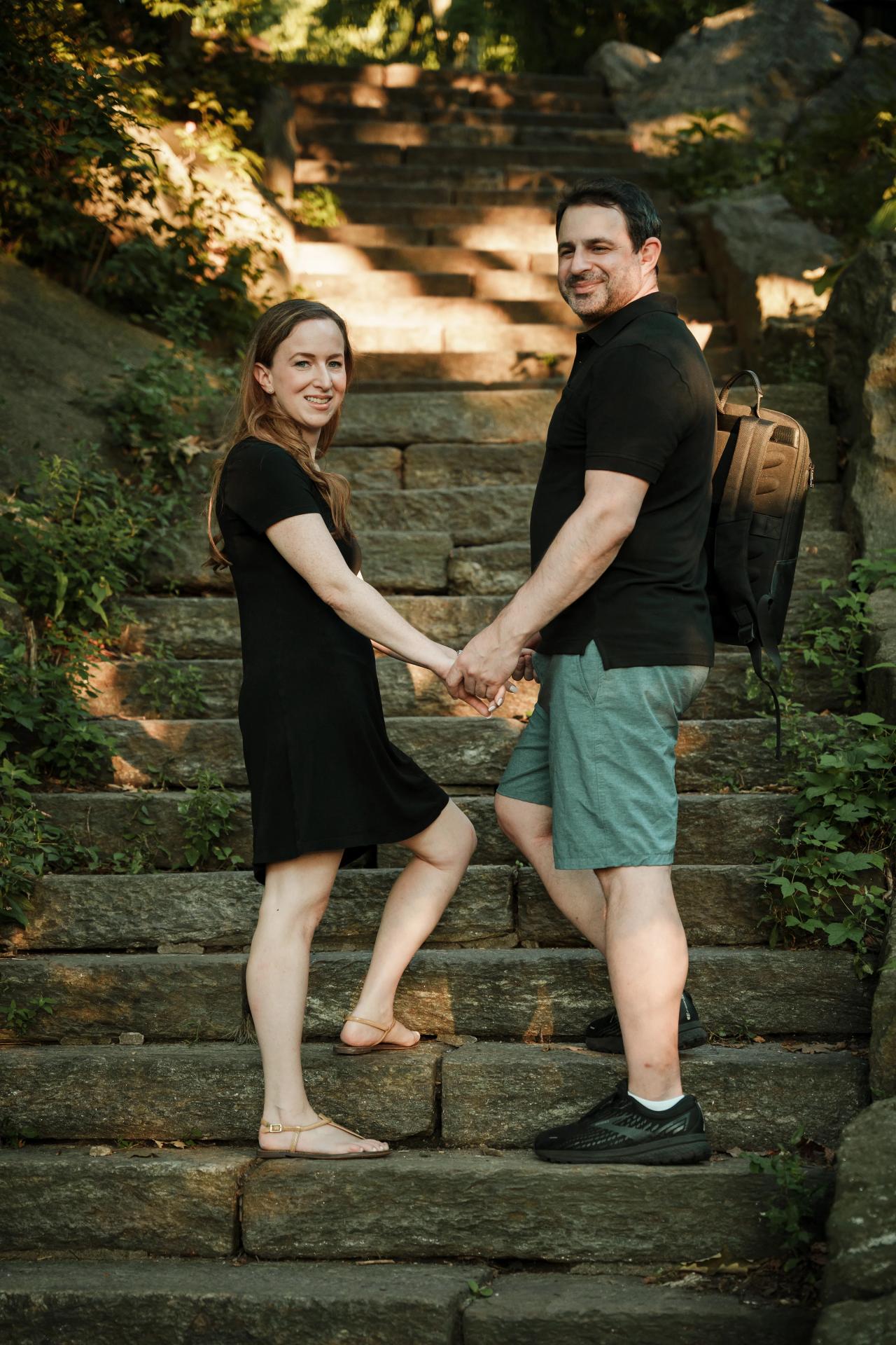 Couple holding hands together on stone garden steps