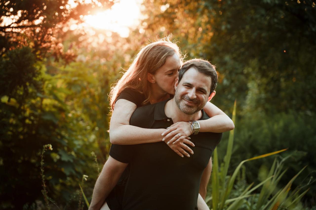 Woman kissing her partner’s cheek during a piggyback portrait