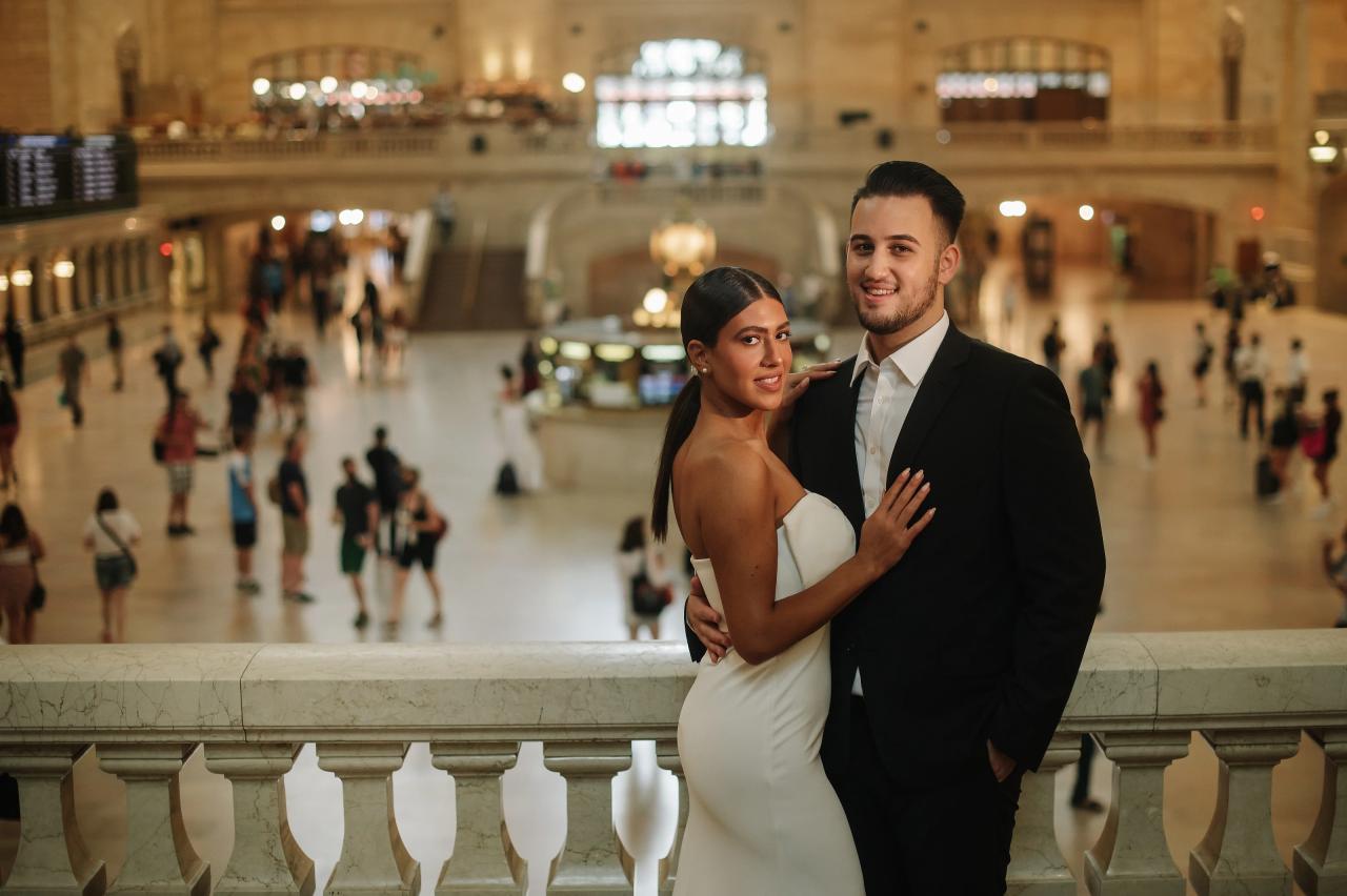 Engaged couple posing together on a Grand Central balcony