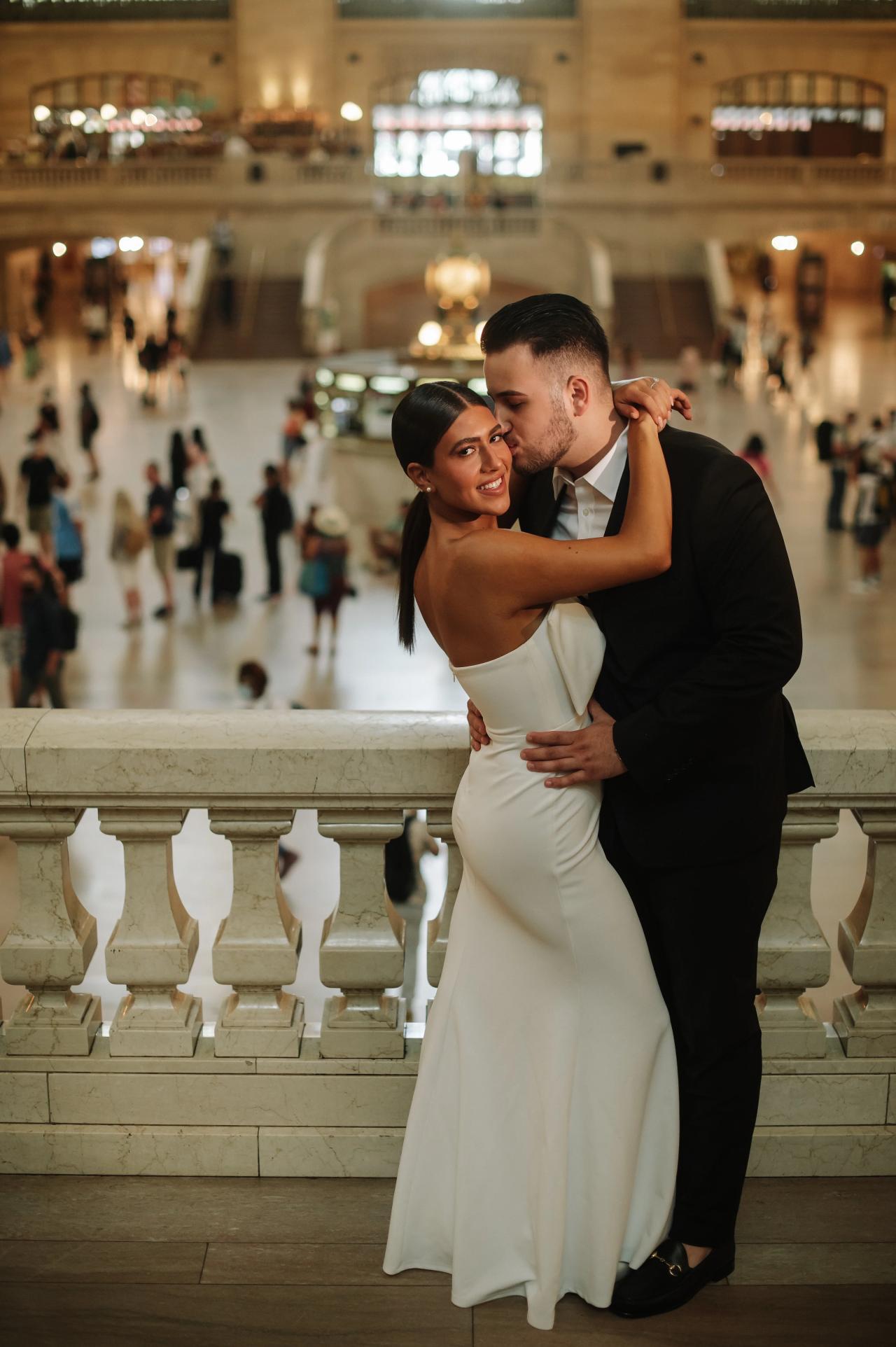 Couple embracing in formal clothes with Grand Central behind them